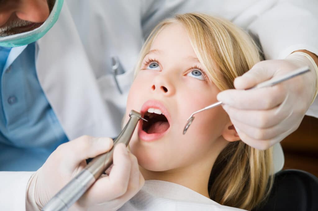 Dentist examines child's teeth